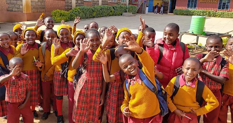 Children of Gitombo village, Kenya, smiling and
holding donated soccer gear